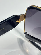 Sunglasses side close-up: gold bridge and black temple with logo detail