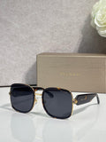Round Bvlgari sunglasses with black frame, gold accents, dark tinted lenses