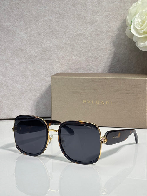 Round Bvlgari sunglasses with black frame, gold accents, dark tinted lenses