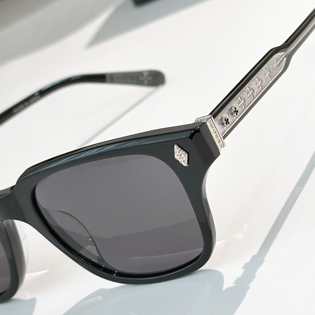 Black square sunglasses with dark tinted lenses and textured silver patterned temple arm
