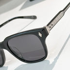 Black square sunglasses with dark tinted lenses and textured silver patterned temple arm