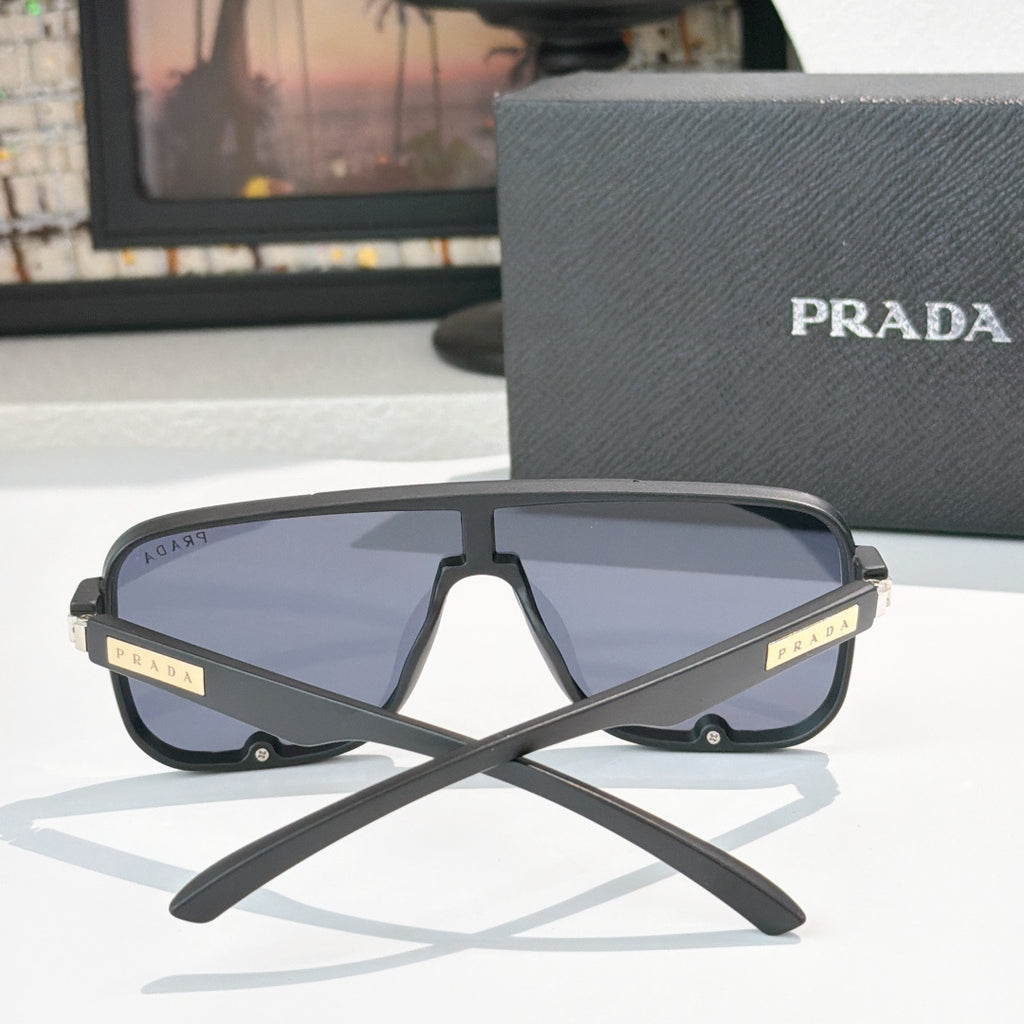 Prada black rectangular sunglasses, front view with tinted lenses and gold logo hinge