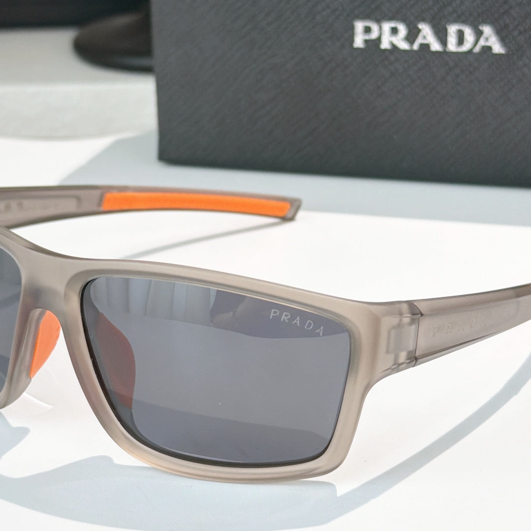 Prada sunglasses close-up: beige frame with orange detail and dark tinted lens