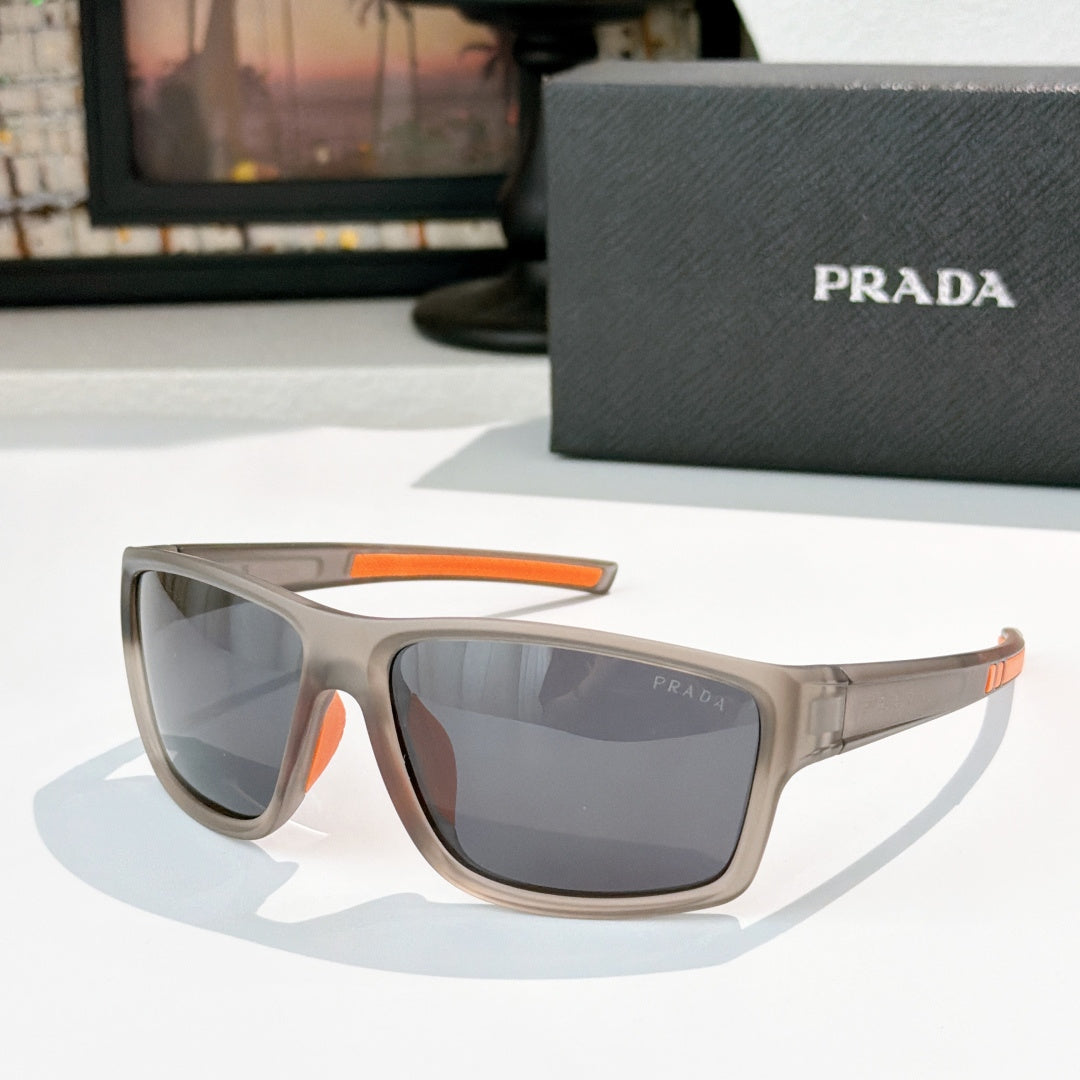 Prada sunglasses with beige frame, orange accent arms, dark tinted lenses