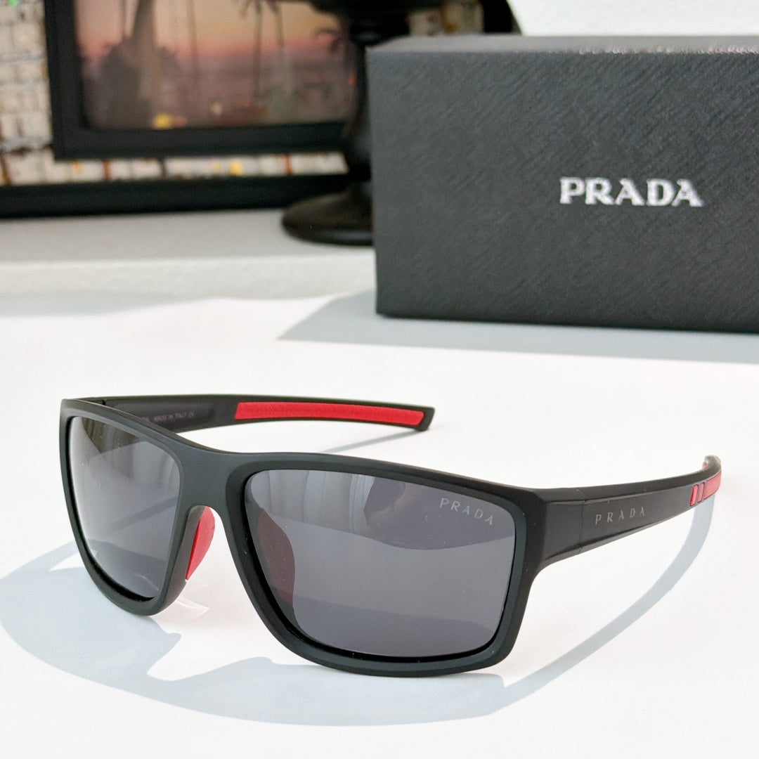 Prada sunglasses with black frame, red accent on upper arm, tinted lenses