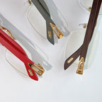 Cartier eyeglasses detail view: red, dark green, and brown temples with gold hinges