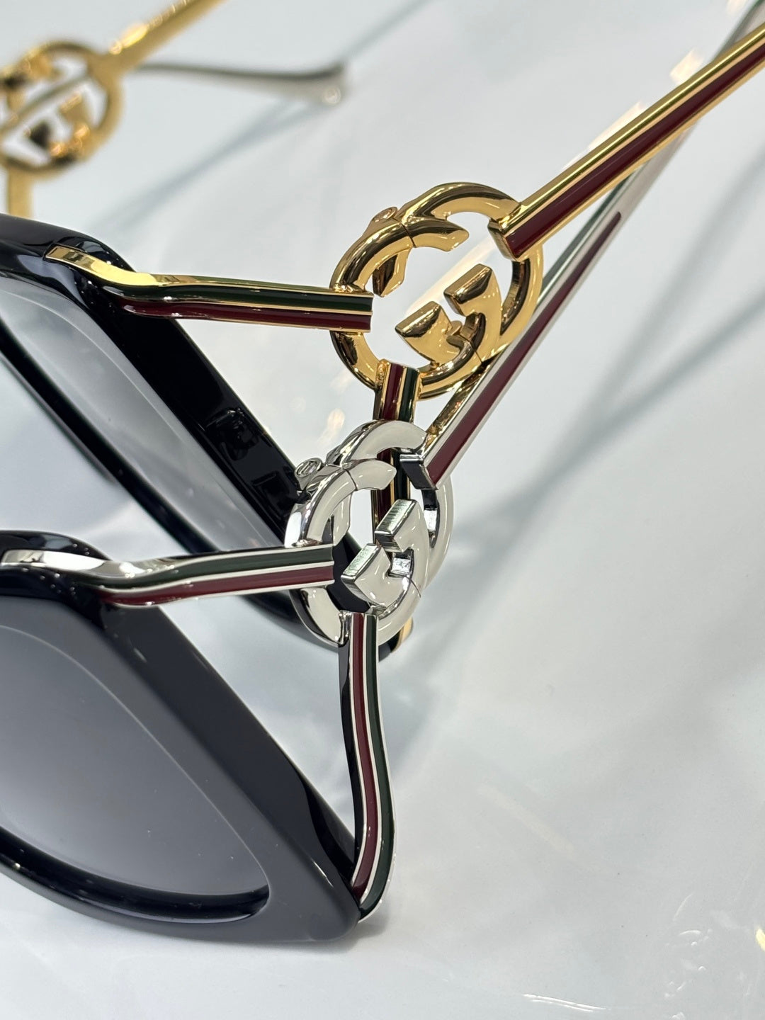 Gucci sunglasses close-up: gold and silver hardware detail on the temple