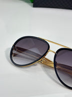 Bottega Veneta oval sunglasses close-up with dark lenses and gold frame