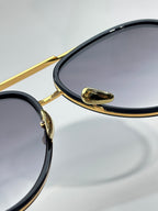 Bottega Veneta sunglasses close-up of gold hinge and dark oval lens