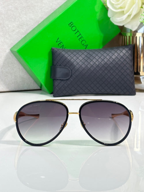 Bottega Veneta round sunglasses with dark lenses, black trim, and gold arms