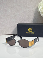 Sunglasses with gold frame, dark brown lenses, black temple with gold logo