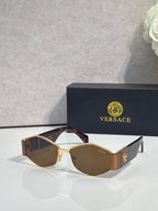Sunglasses with gold frame, dark brown lenses, patterned temple, gold logo detail
