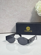 Sunglasses with black frame, dark lenses, gold logo detail on temple