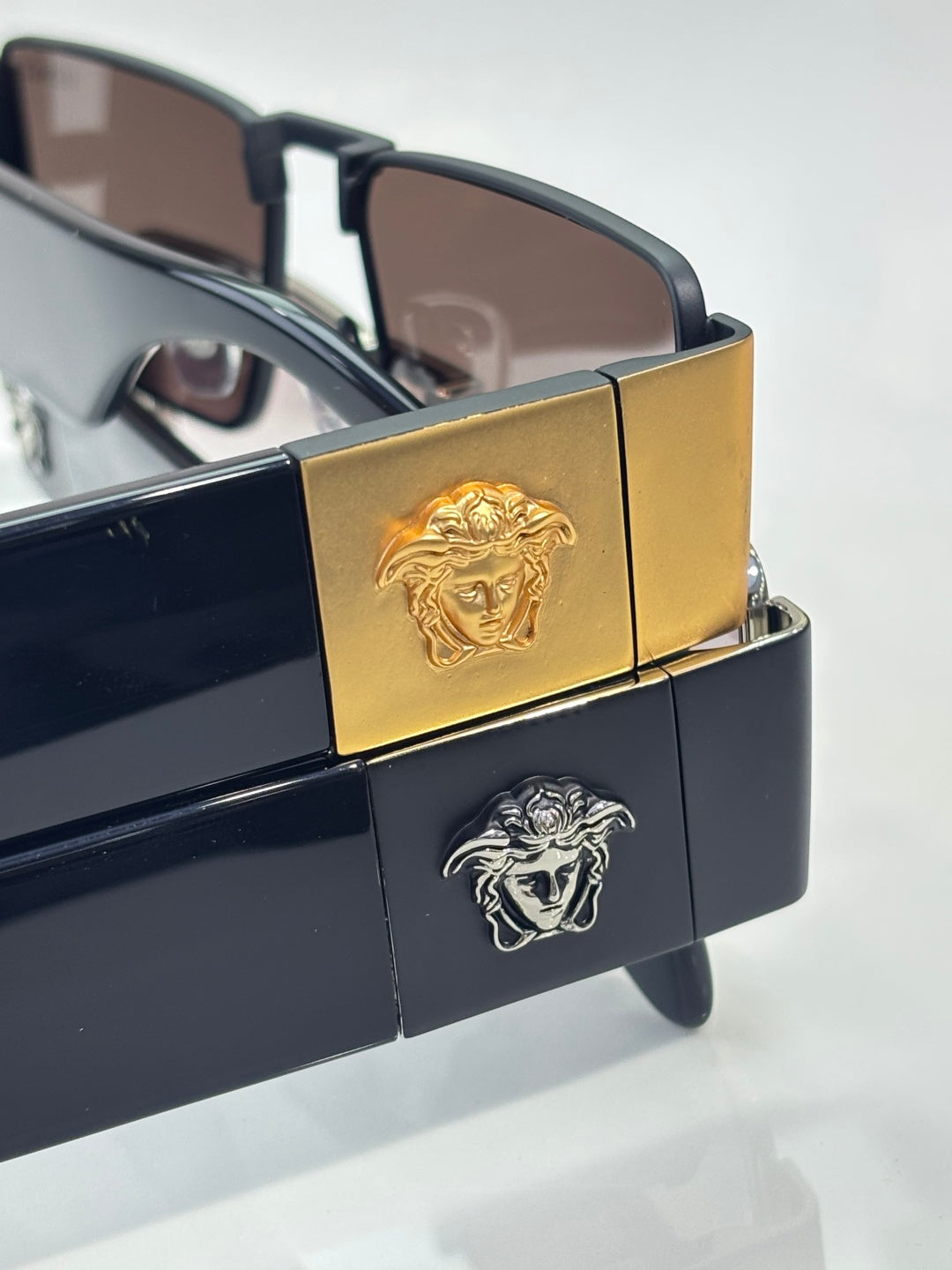 Versace sunglasses medallion detail on frame: gold and black panels with dark lenses