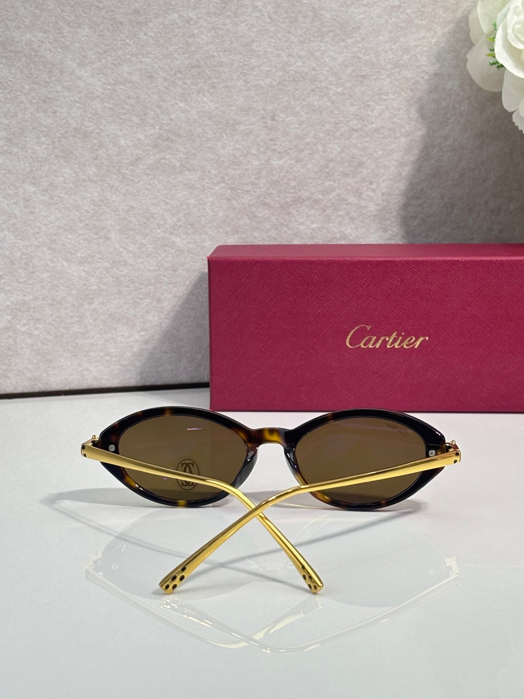 Gold-tone oval sunglasses with brown tinted lenses and slim metal frame