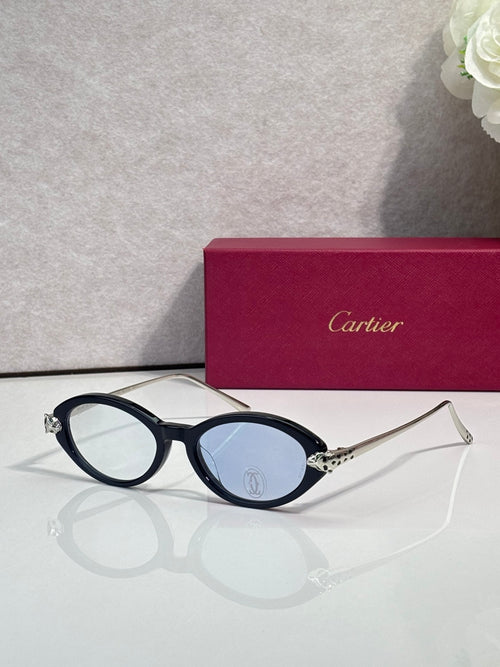 Black oval glasses with gold temples and dark tinted lenses