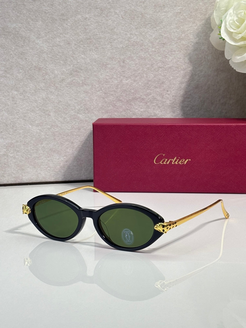 Oval glasses front view with dark lenses and gold-tone temples