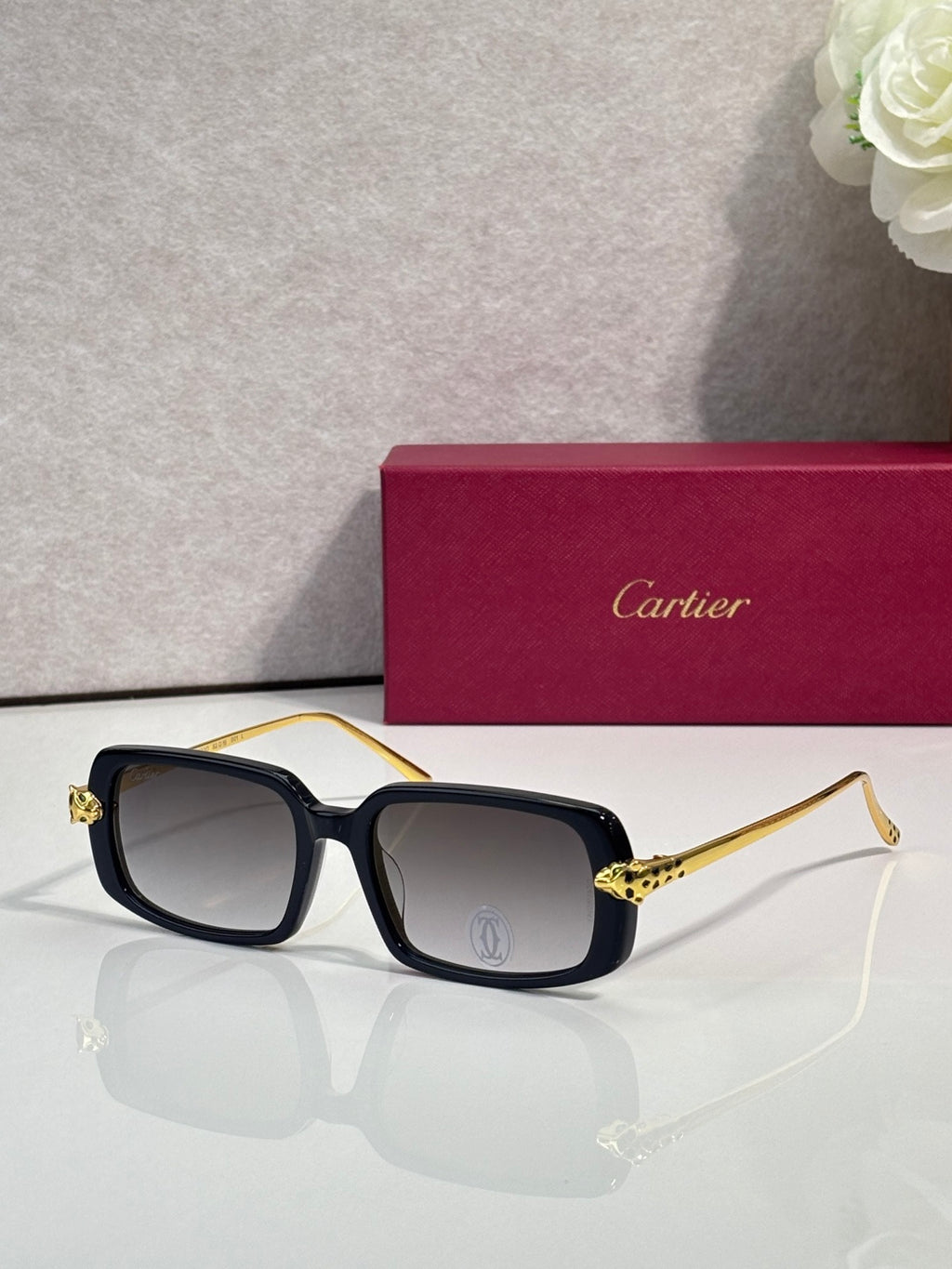 Cartier eyeglasses with dark frame and gold-tone temples, gray tinted lenses