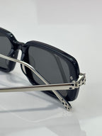 Black eyeglasses close-up with dark lenses and patterned metal temple tips