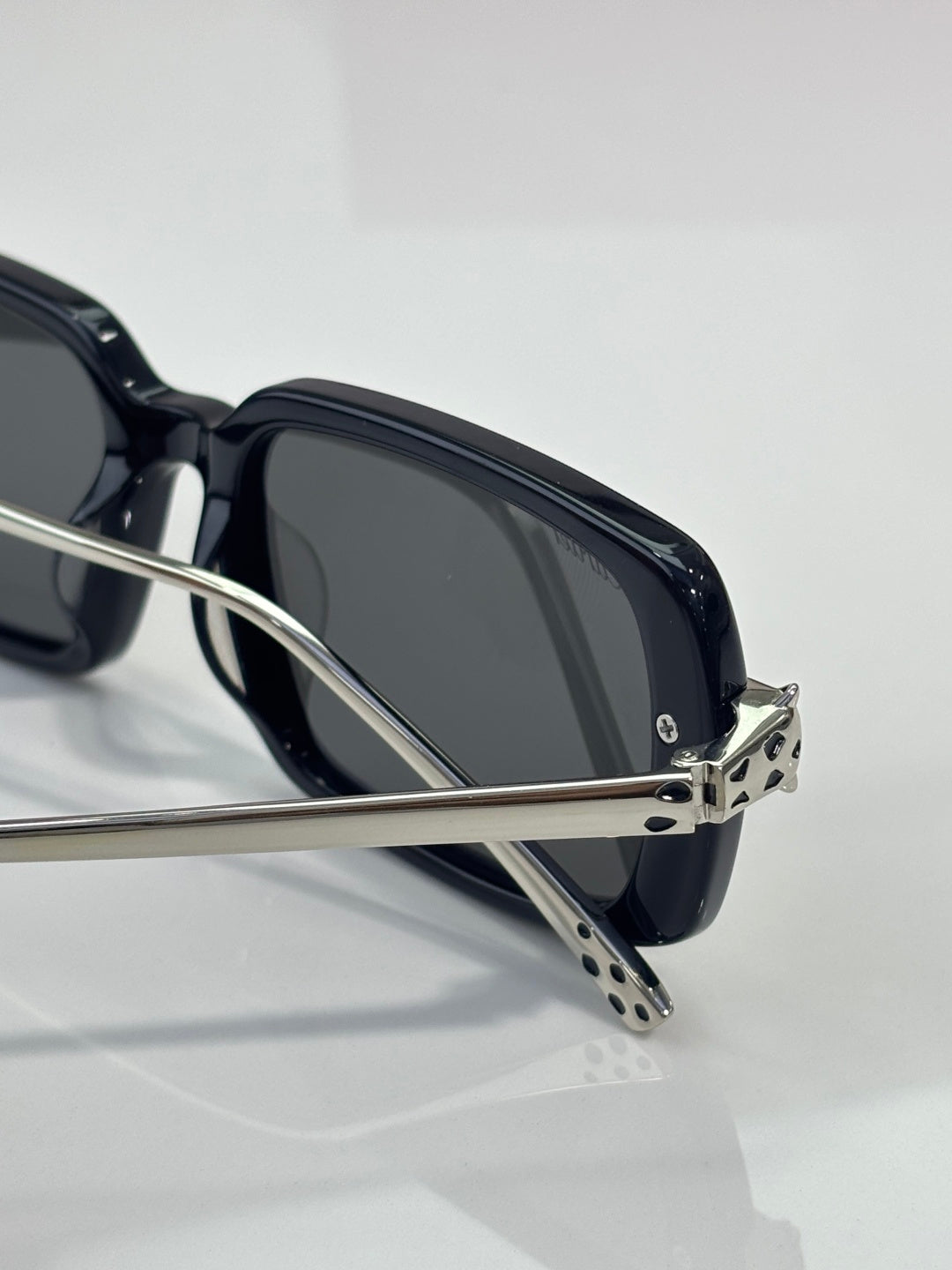 Black eyeglasses close-up with dark lenses and patterned metal temple tips