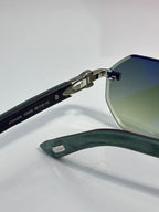 Cartier round eyeglasses with green temples, silver metal frame, and engraved arms