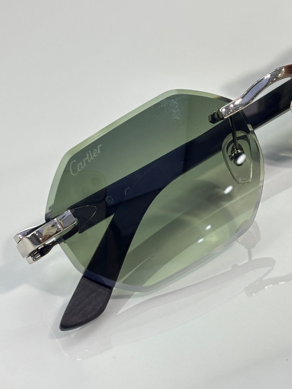Cartier glasses side view: green lenses with silver bridge and dark temples