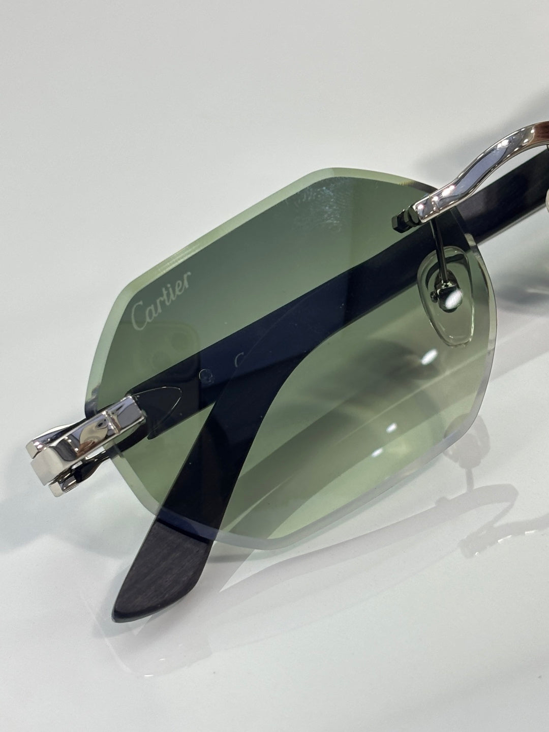 Cartier glasses side view: green lenses with silver bridge and dark temples