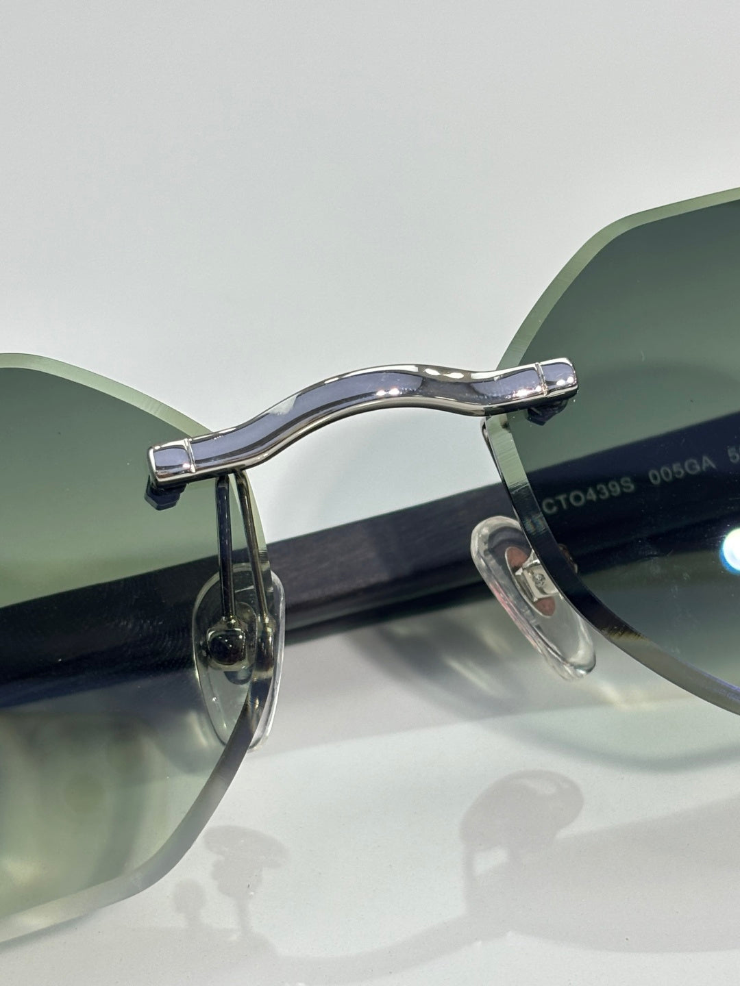 Cartier glasses angled view: light green lenses with silver frame and dark temples