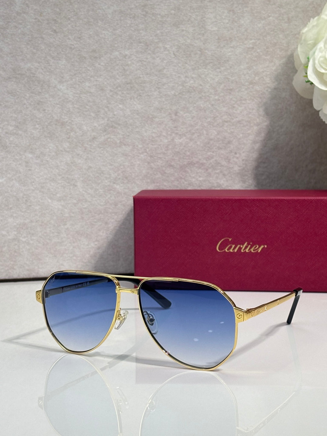 Metal sunglasses with blue-tinted lenses, gold frame and black tips