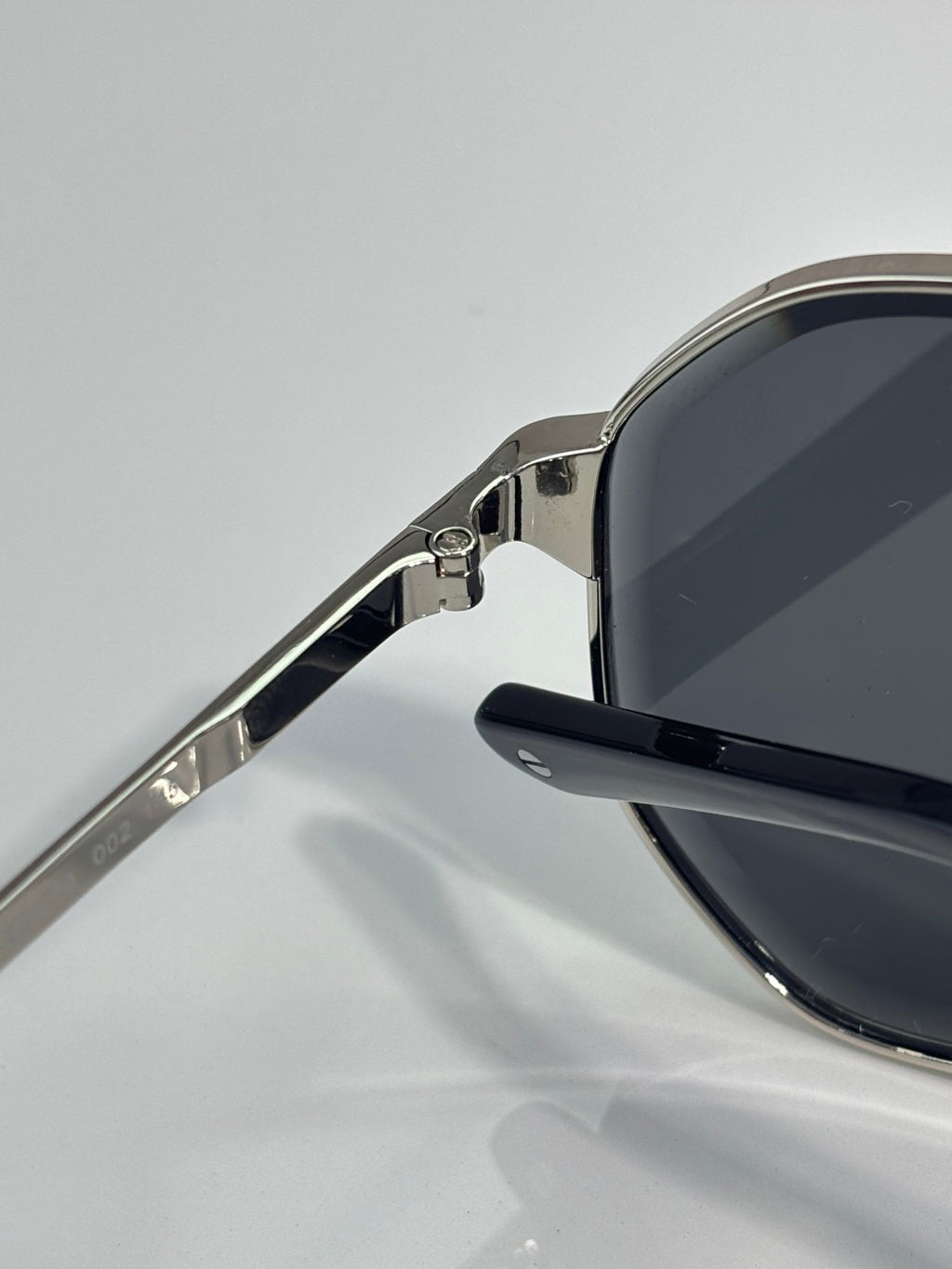 Cartier sunglasses side view: silver metal frame with dark lens and hinge