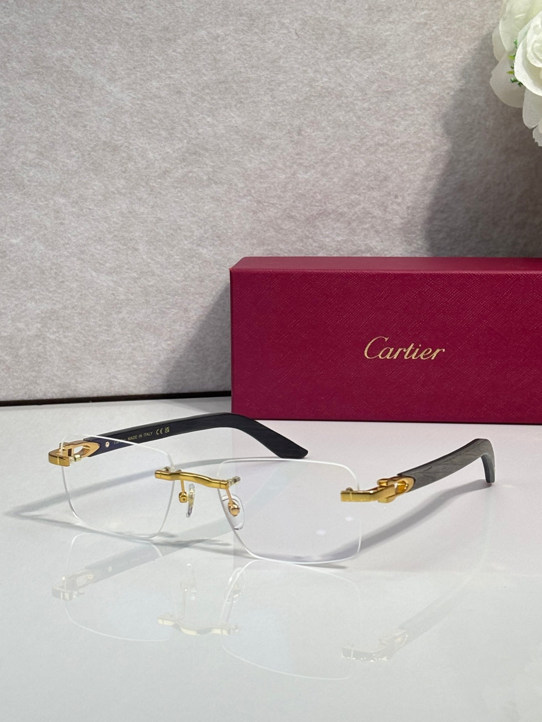 Eyeglasses with clear lenses, gold metal frame, dark arms and gold-toned accents