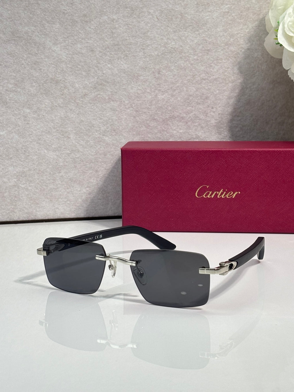 Cartier glasses, black frame with gold-tone arms and dark gray lenses