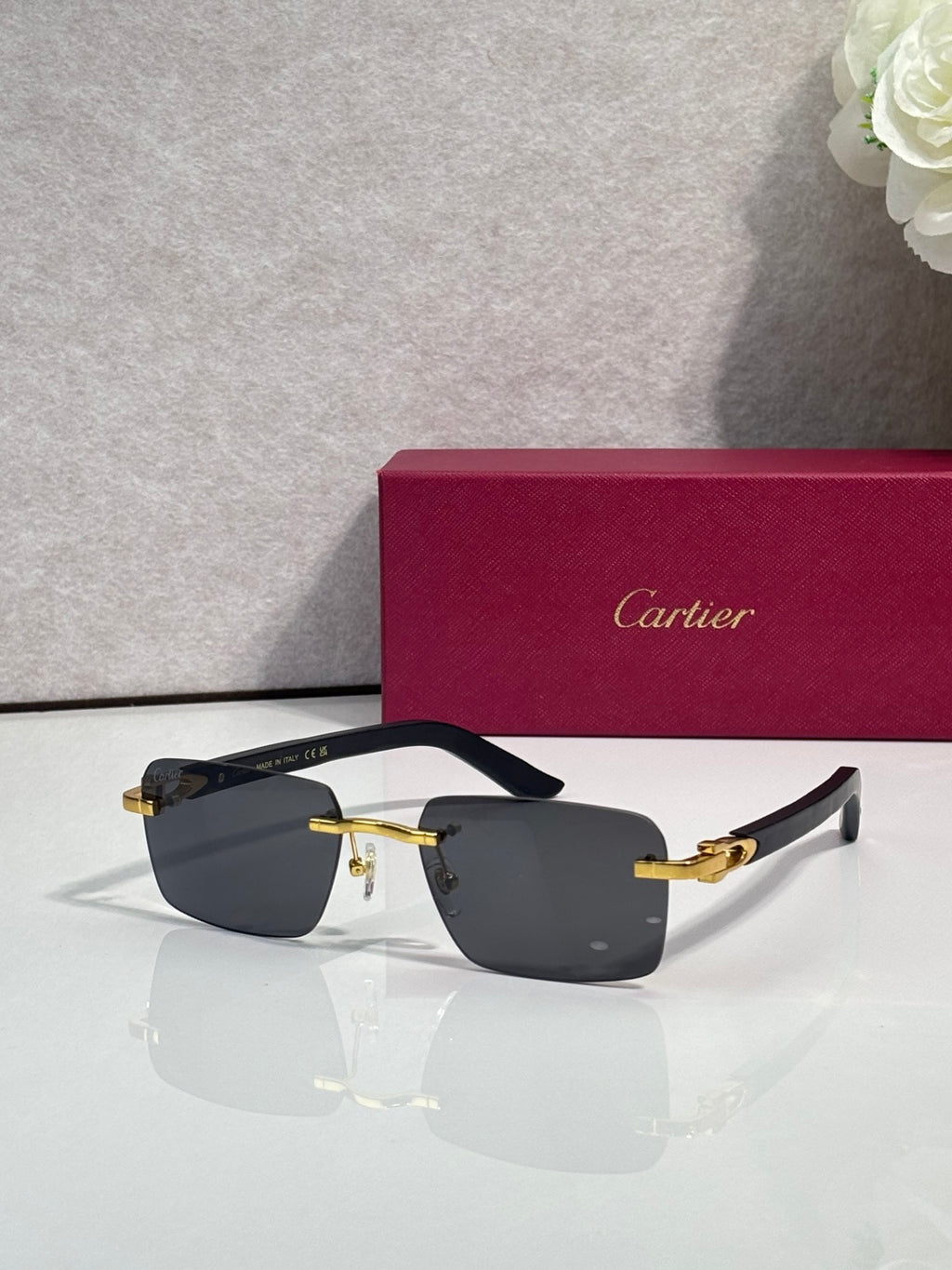 Cartier glasses, black frame with gold-tone hinges and gray-tinted lenses