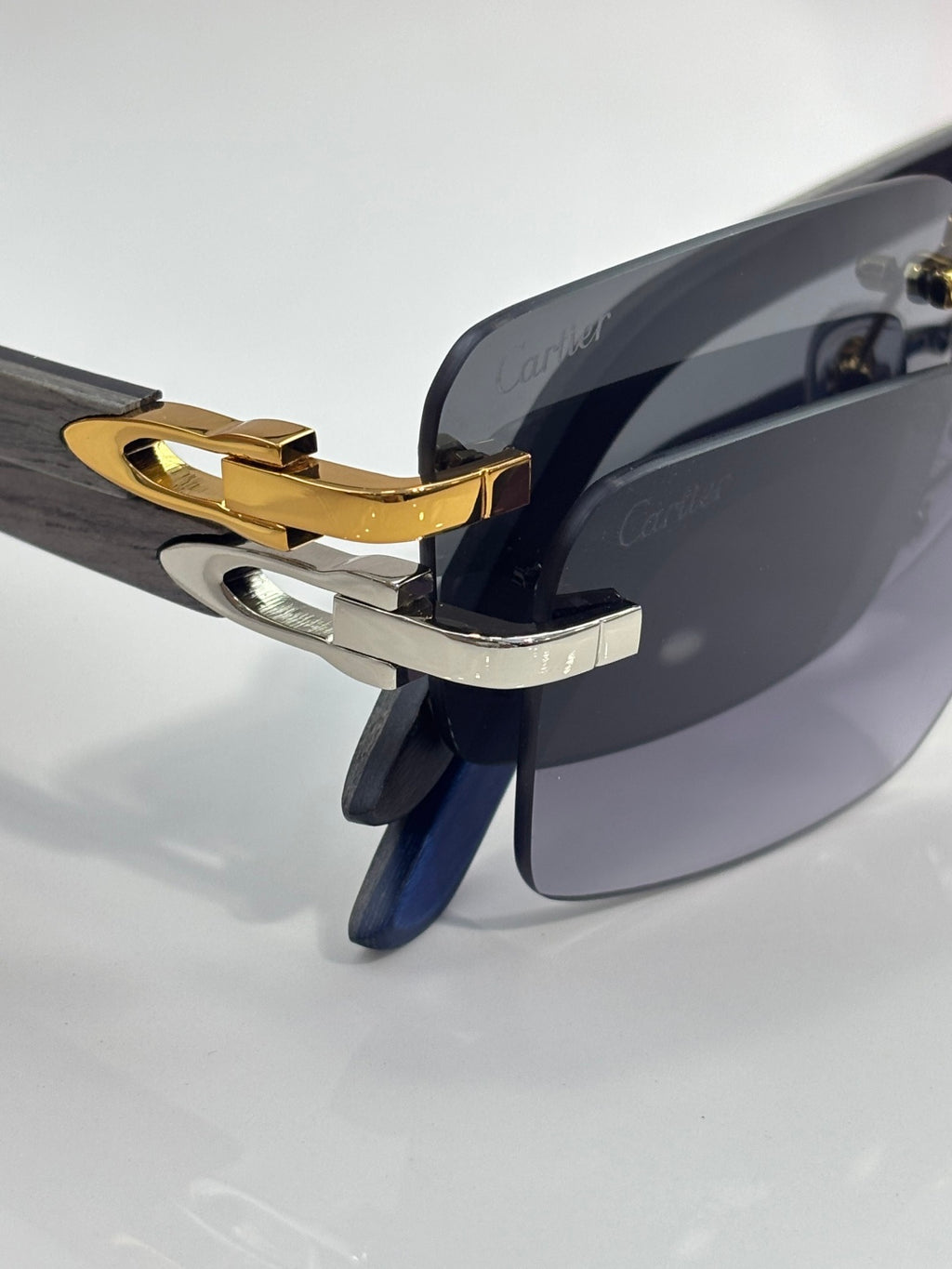 Cartier sunglasses side close-up with gold hinge and dark blue temple