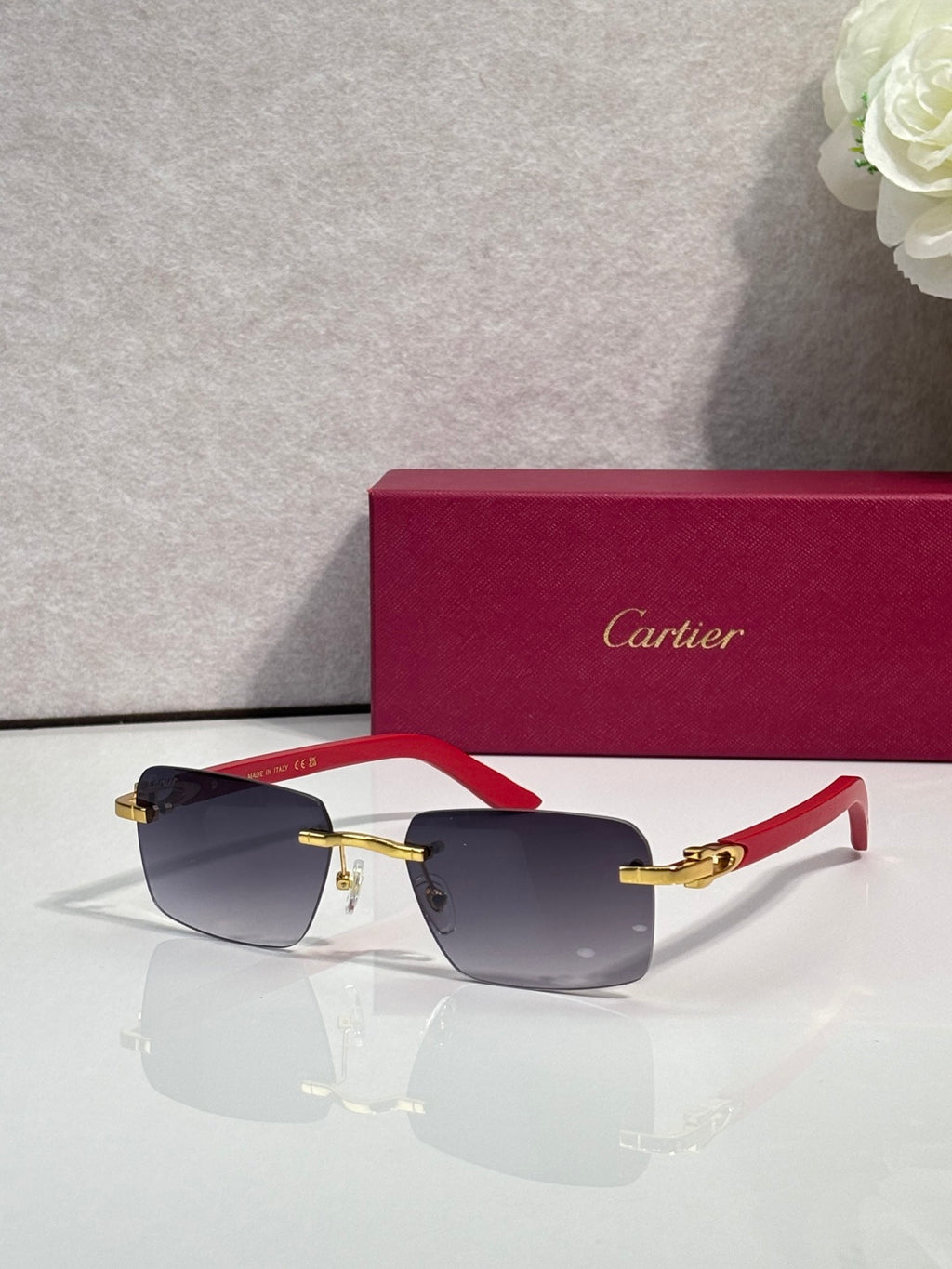 Cartier sunglasses with dark frames, red temple tips, and gold metal accents