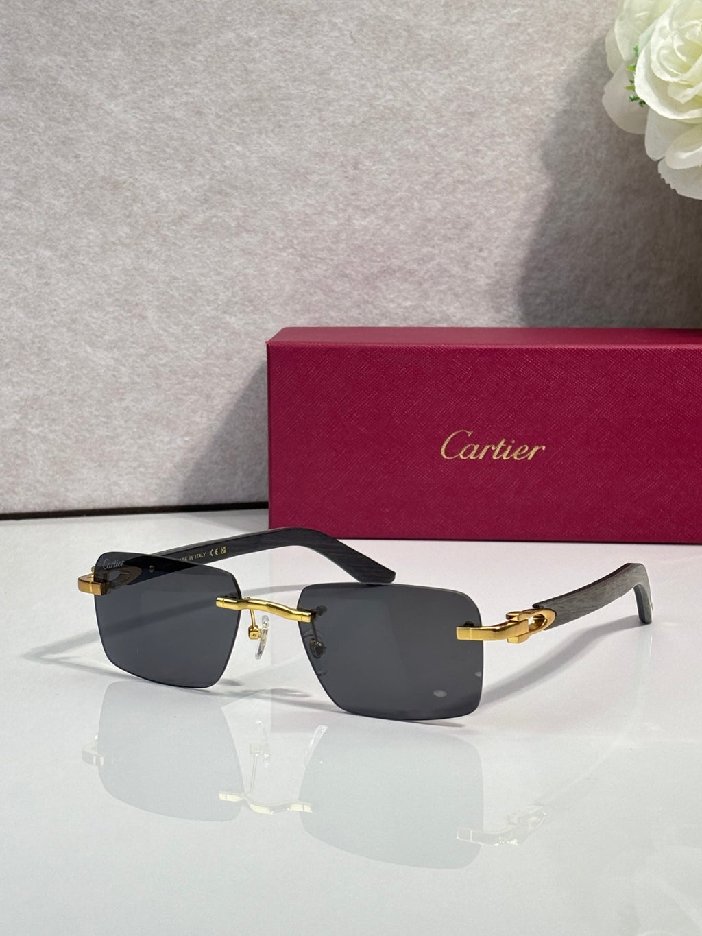 Cartier sunglasses with black frames, dark lenses, and gold metal arms and hinges