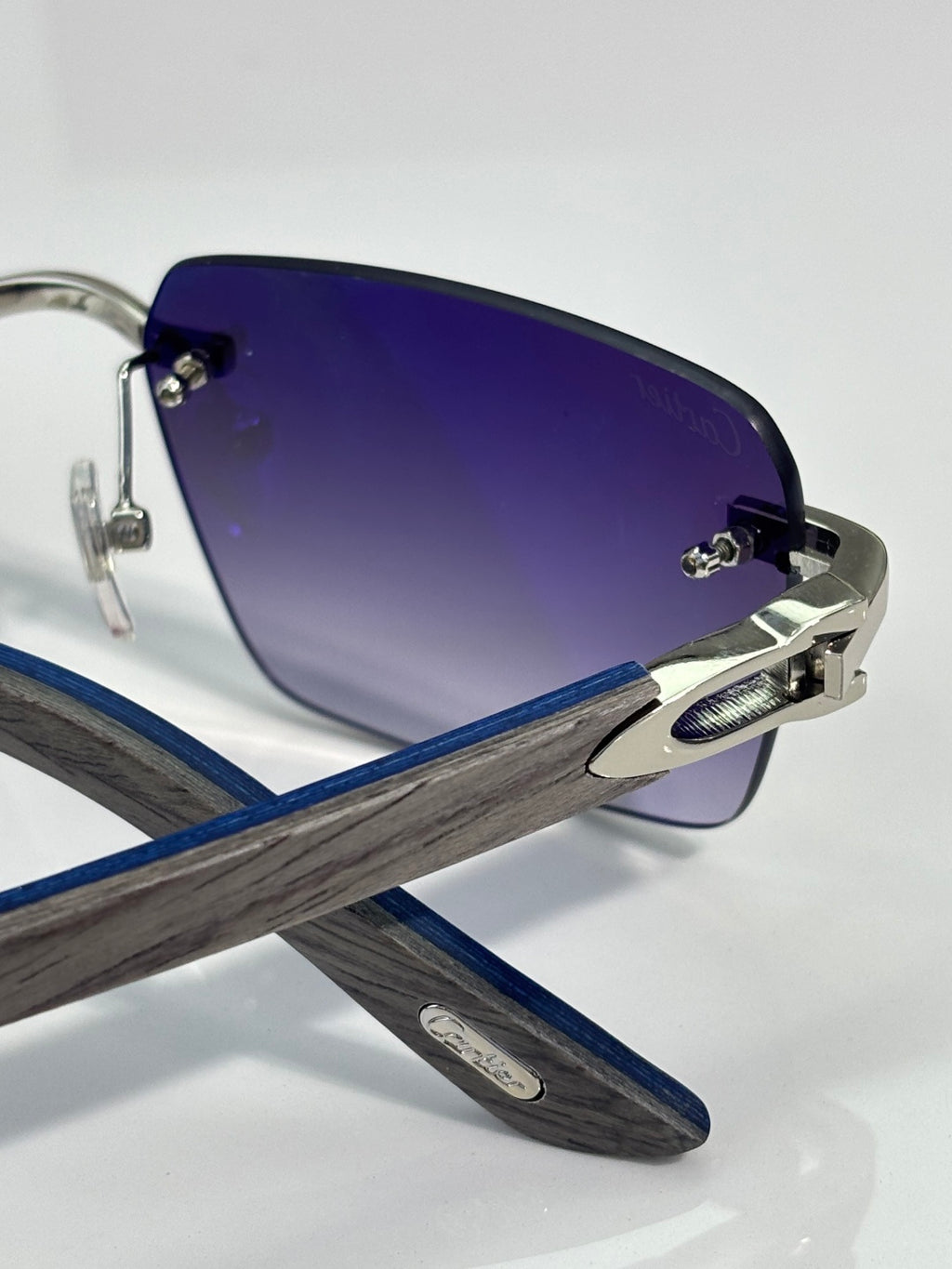 Cartier sunglasses close-up of dark blue lenses and silver hardware on the arm