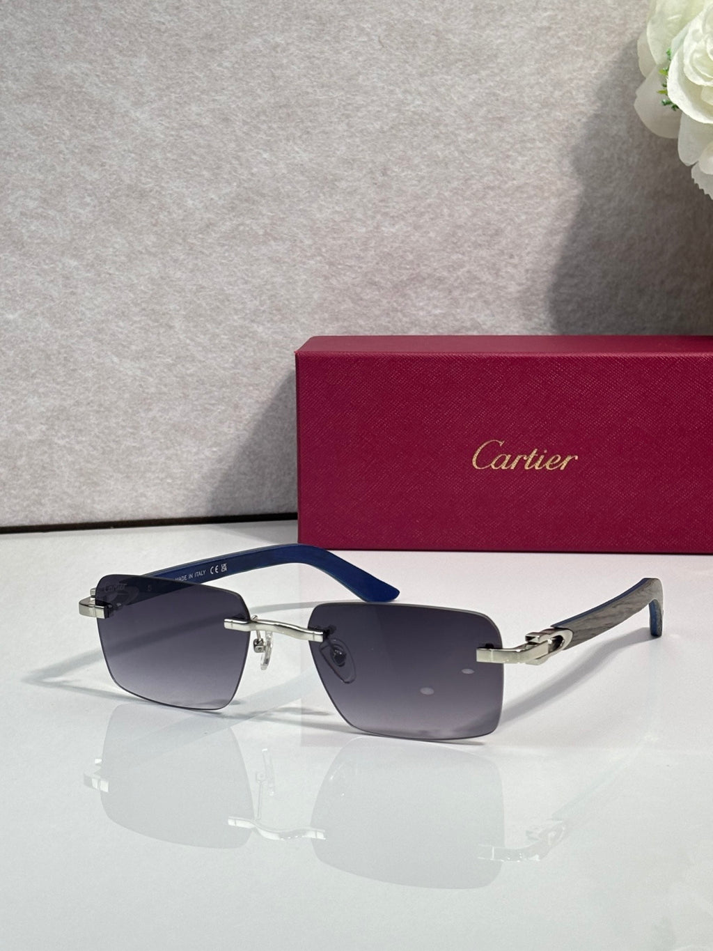 Cartier sunglasses with dark frames and blue gradient lenses with gold metal details