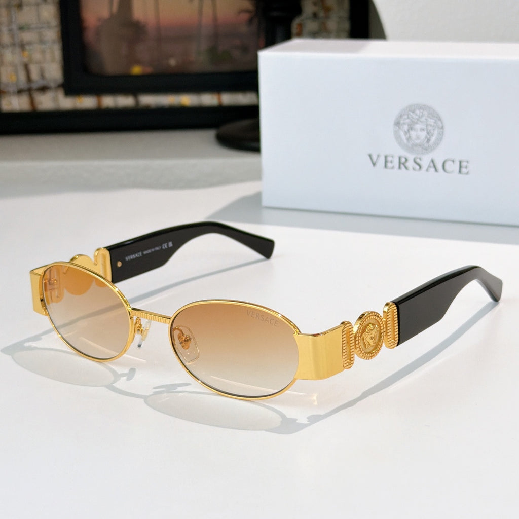 Versace sunglasses: gold frame, amber-tinted oval lenses, black temple tips.