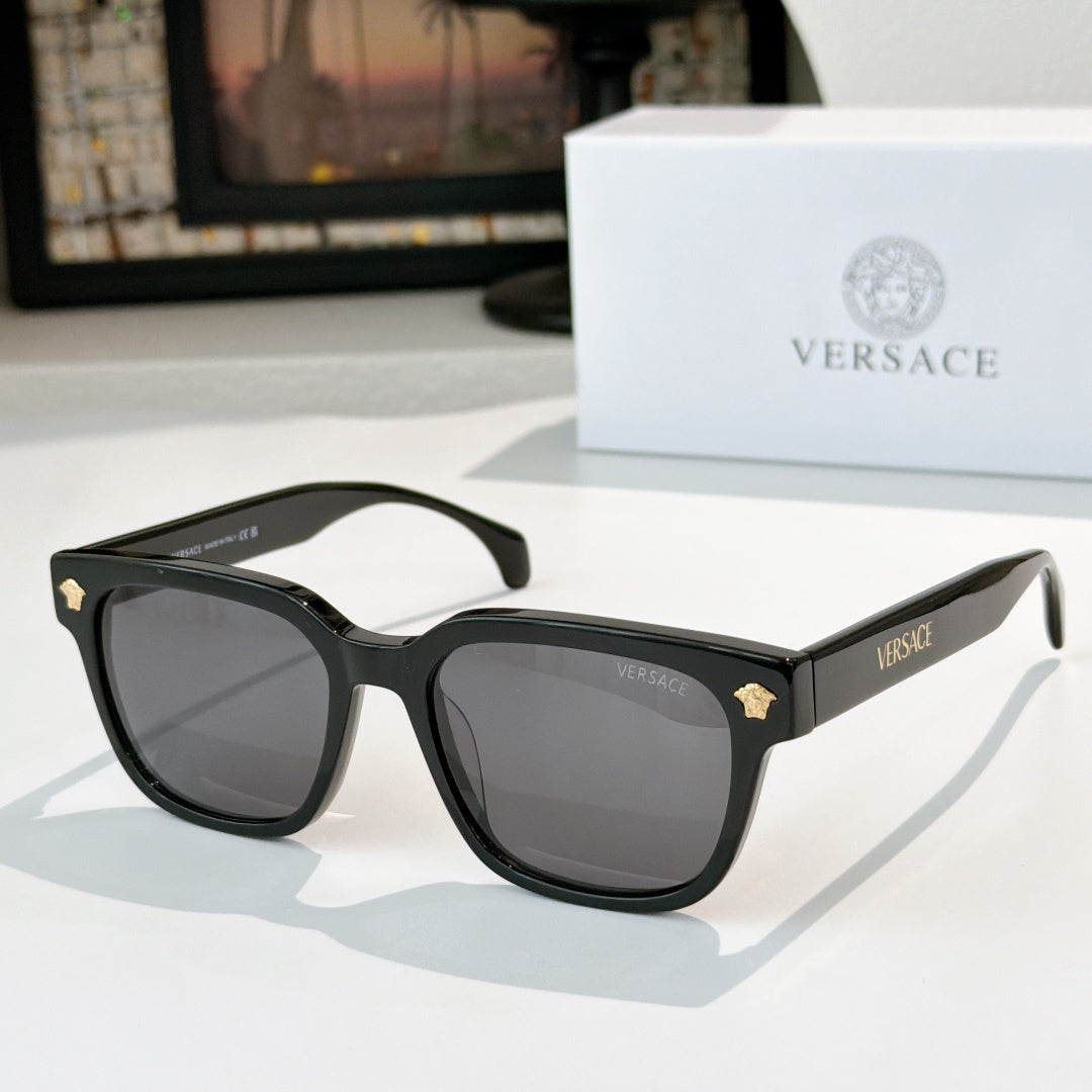 Black cat-eye sunglasses with dark lenses and gold logo hinge details