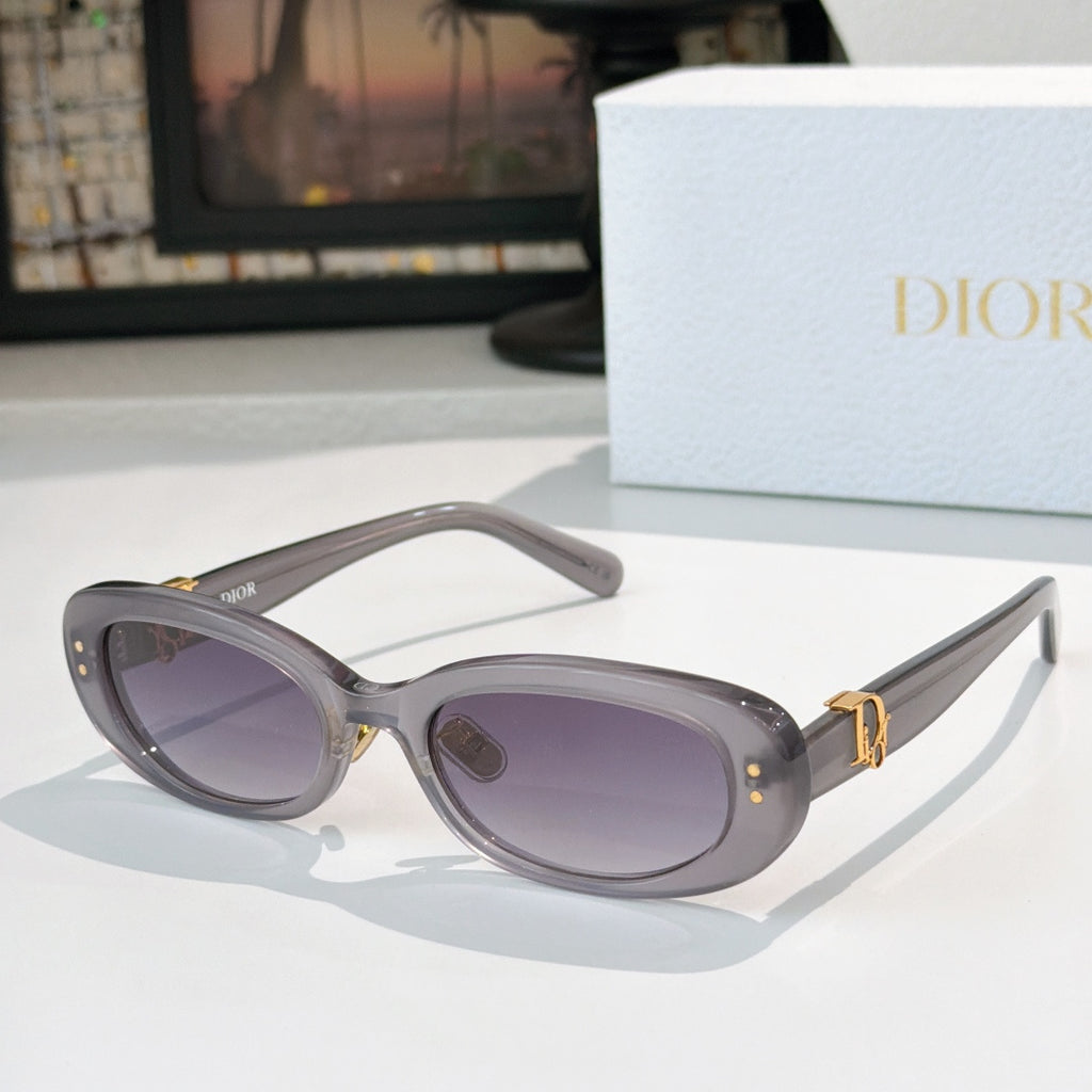 Dior oval sunglasses with dark gray frames, purple lenses, and gold D-logo accents