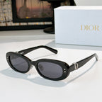 Dior oval sunglasses with black frames, gray lenses, and gold D-logo hinge detail