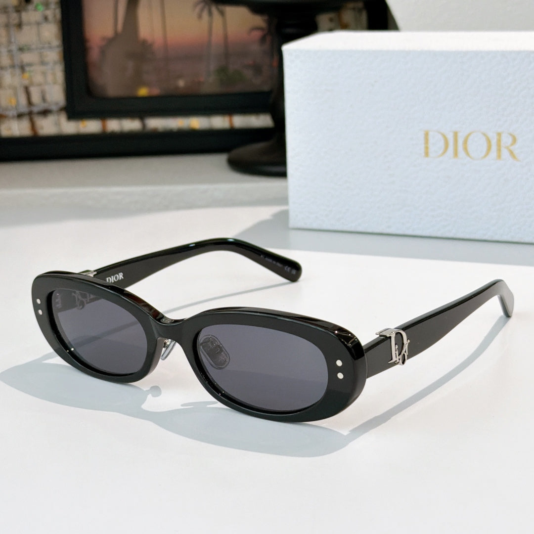 Dior oval sunglasses with black frames, gray lenses, and gold D-logo hinge detail