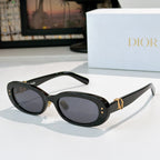 Dior oval sunglasses with black frames, dark lenses, and gold D-logo side accents