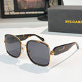 Bvlgari sunglasses with black frames, gold accents, and dark tinted lenses
