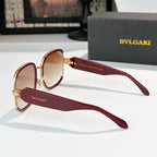 Bvlgari sunglasses with maroon frames, gold accents, and amber tinted lenses