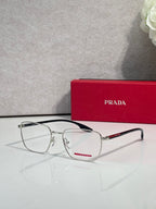 Front view black eyeglasses with clear lenses and red logo accent on temple