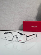 Black eyeglasses with clear lenses, red logo bar, and metal hinge details
