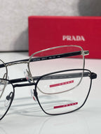 Metal and black eyeglasses with clear lenses and red Prada logo on temples