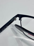 Black eyeglass temple and hinge close-up with clear lens edge visible.